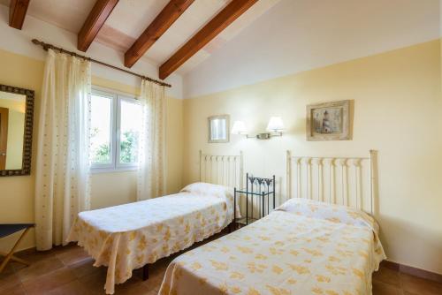 卡兰博希Villa Aldebaran的一间卧室设有两张床和窗户。