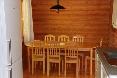 努尔梅斯Aronsalmen Lomamökit的厨房配有带椅子的木桌