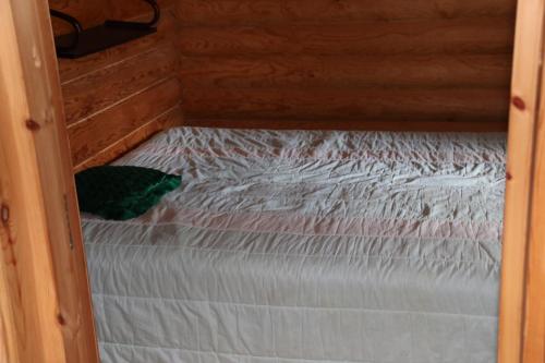 努尔梅斯Aronsalmen Lomamökit的小木屋内的一张小床,