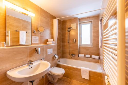 穆劳附近圣格奥尔根Club Hotel am Kreischberg的浴室配有盥洗盆、卫生间和浴缸。