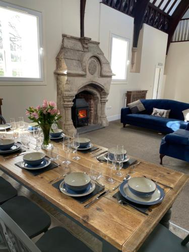 BurwartonThe old school house的木桌、盘子、玻璃杯和壁炉