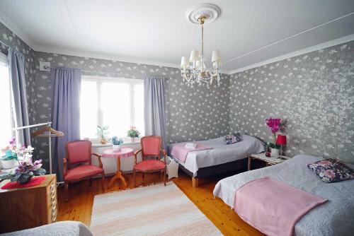 ÖverkalixVilla Sisu的一间卧室配有两张床、椅子和吊灯。