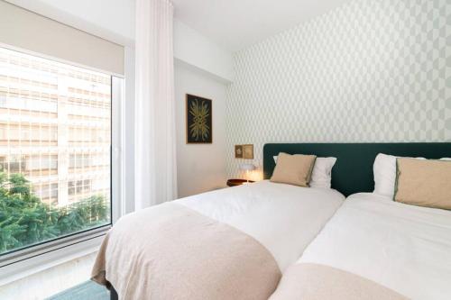 里斯本Liberdade Terrace Apartment的一间卧室设有两张床和窗户。