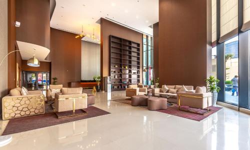 迪拜FAM Living - RP Heights - 3 Mins Walk to Burj Khalifa & Dubai Mall Downtown Dubai的大楼内一个带沙发和椅子的大堂