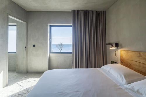 蓬塔德尔加达CASA DA ILHA - Slow Living Residence & Suites的一间卧室设有一张大床和一个大窗户