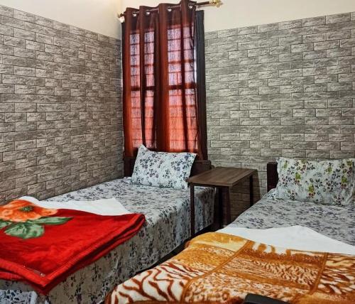 古瓦哈提D.D Lodge的一间设有两张床和砖墙的房间