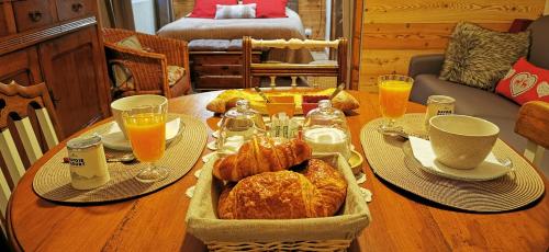 GrignonLa grange de Lina的一张桌子,上面放着羊角面包和橙汁