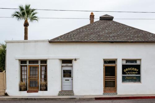 土桑Historic Adobe 3br Home in Downtown El Presidio的一座白色的建筑,前面有棕榈树