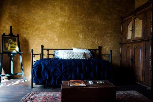 土桑Historic Adobe 3br Home in Downtown El Presidio的一间卧室配有一张带蓝色毯子和一张桌子的床。