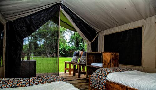 姆托瓦姆布Africa Safari Camping Mto wa Mbu的帐篷卧室配有两张床和一张桌子