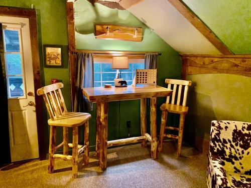 沃特伯里Grunberg Haus Inn & Cabins的配有木桌和两把椅子的房间