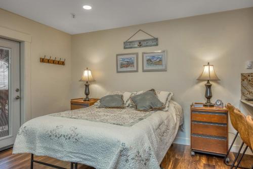 哥德伍德East Condo #202的一间卧室配有一张带2个床头柜和2盏灯的床。