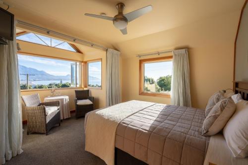 凯库拉尼考旅馆的一间卧室配有一张床、一把椅子和窗户。