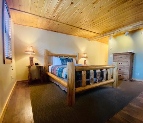 萨利达萨利达美国最有价值旅馆的一间卧室设有木床和木制天花板。