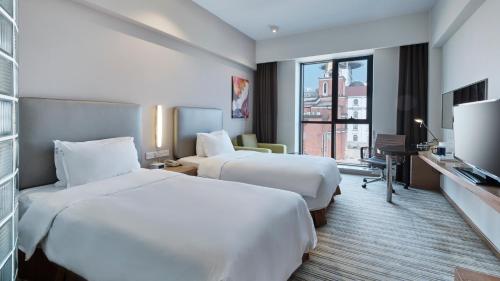 宝山区上海共康智选假日酒店的酒店客房设有两张床和电视。