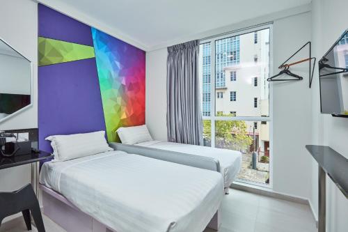 新加坡ibis budget Singapore Ametrine的配有彩虹墙的客房内的两张床