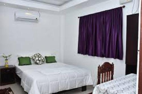 布莱尔港Sushils Bed and Breakfast的一间卧室设有两张床和紫色窗帘