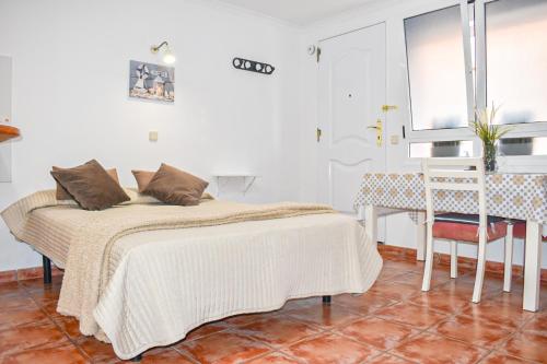 拉加里塔Beachback Studio Apt Low-cost nearby Airport的一间卧室配有一张床、一张桌子和一个窗户。