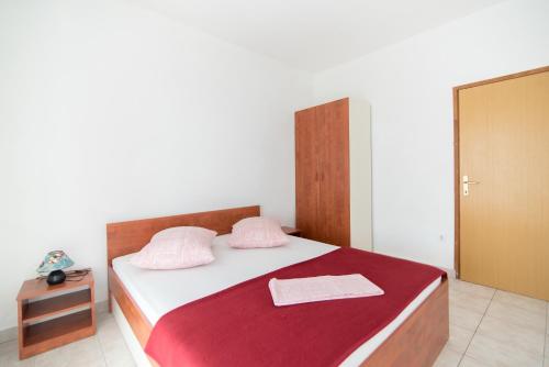 塞尔察Apartments Neva的一间卧室配有一张床铺,床上铺有红色毯子