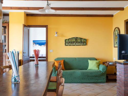 因佩里亚Apartment Casa della Mimosa by Interhome的客厅配有绿色沙发和桌子