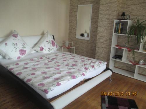 Waldesch祖格边姆民宿的卧室配有白色的粉红色花床