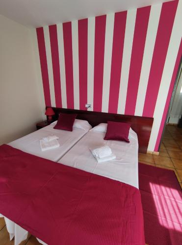 索里亚圣安德烈斯旅馆的一间卧室配有一张红色和白色条纹的大床