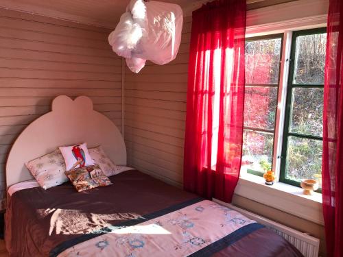 阿沃斯塔Fisherman s Cottage overlooking the river的一间卧室配有床和红色窗帘的窗户