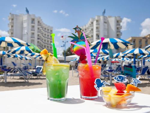 西尼加利亚HR Senigallia, già Hotel Ritz的坐在海滩桌子上享用三杯鸡尾酒