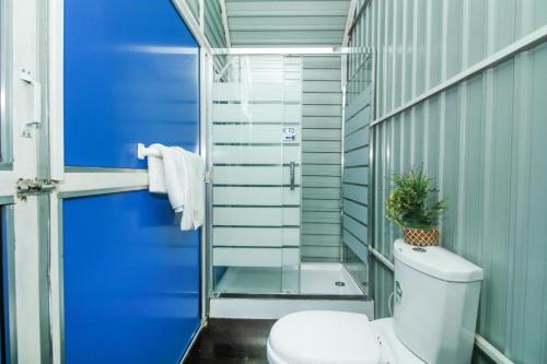 卡图纳耶克Airport A4 Transit Hub - Eco Chalets的一间带卫生间和蓝色门的浴室