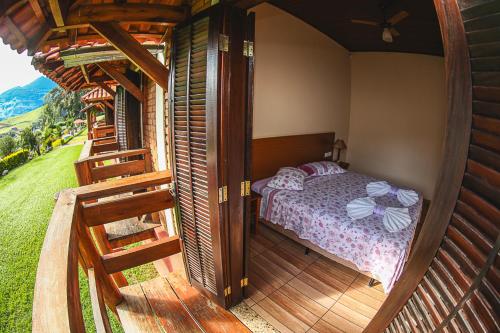 帕萨夸特鲁Pousada Pedra da Mina的一间卧室,在木甲板上配有一张床