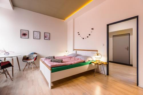 布尔诺Design apartments Brno-center的一间卧室配有一张床铺和一张桌子,还有一间用餐室