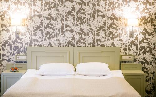 塔尔图安托尼斯酒店的卧室配有白色的床和花卉壁纸