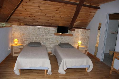 Liesville-sur-Douvechevrerie de la huberdiere的客房设有两张床,配有木制天花板和木地板。