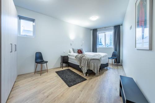 弗吕济Nortia Apartments的一间卧室配有一张床和两把椅子