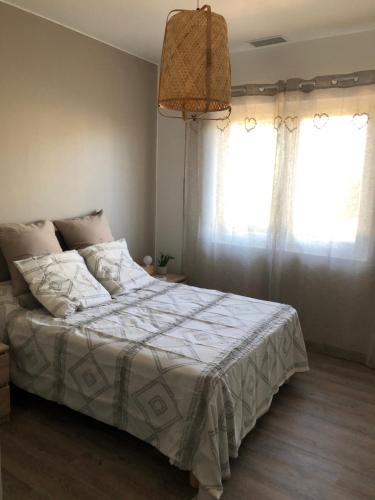贝尔热拉克Villa Bergerac avec Piscine的一间卧室配有一张带白色棉被的床和两个窗户