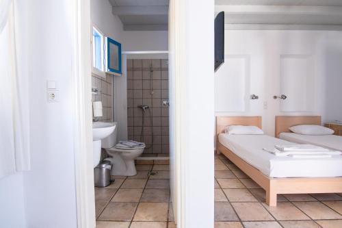 迈洛波塔斯Far Out Village Hotel的一间卧室配有一张床,浴室设有卫生间