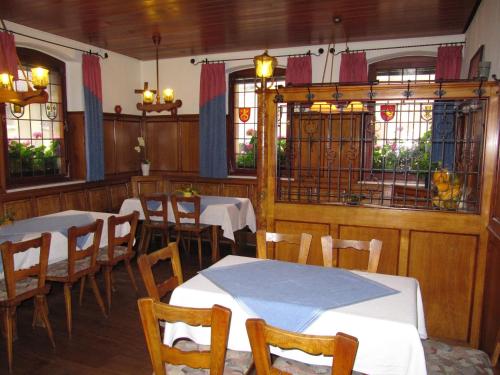 洪堡古尔登罗布雷恩宾馆的用餐室设有桌椅和窗户。