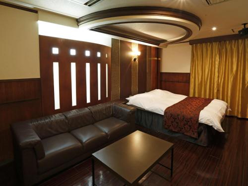 各务原市Hotel Fine Garden Gifu的酒店客房设有一张沙发和一张床