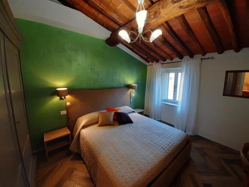 卢卡Il Vicolo的一间卧室配有一张带绿色墙壁的床