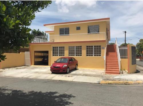 圣胡安San Juan Apartments的停在房子前面的红色汽车