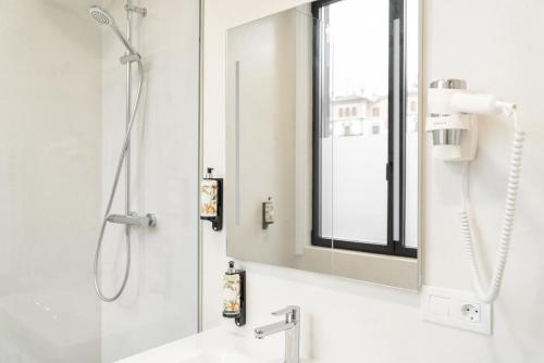 圣塞瓦斯蒂安Bidaia Boutique Hotel的带淋浴和盥洗盆及镜子的浴室