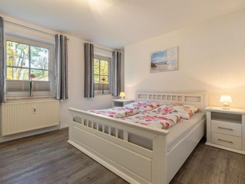 博尔滕哈根Stunning Apartment in Boltenhagen的一间卧室设有一张大床和两个窗户。