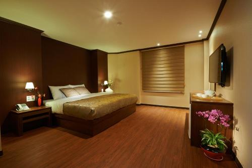 济州市四季酒店的一间卧室配有一张床和一台平面电视