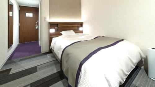 高知高知太平洋大酒店 的酒店客房带一张床和走廊