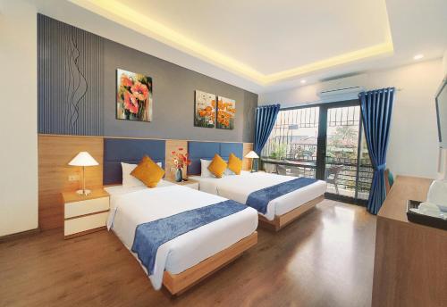 河内Hanoi Amorita Boutique Hotel & Travel的酒店客房设有两张床和窗户。