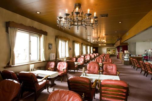 立山町立山酒店的餐厅设有红色的桌椅和吊灯