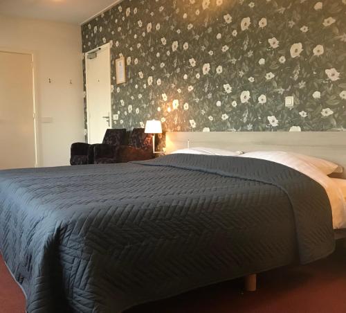 诺格诺格酒店的一间卧室配有一张带花卉墙壁的床