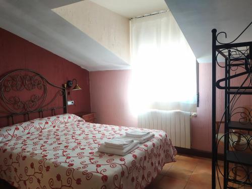 拉斯马哈达斯Apartamento Los Callejones的红色卧室,配有带毛巾的床