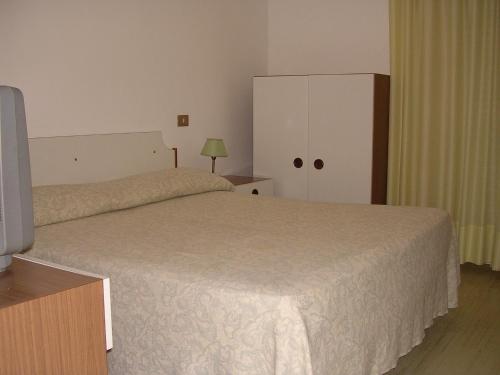 法尔科纳拉·玛里提马阿尔伯吉奥腾达佛得角酒店的一间卧室配有一张床、一个橱柜和一台电视