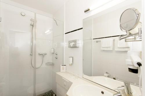 美因河畔法兰克福Hotel Scala Frankfurt City Centre的带淋浴和盥洗盆的白色浴室